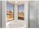 Bathroom with a soaking tub with windows offering desert views and a glass-enclosed shower at 8752 E Range Rider Trl, Mesa, AZ 85207
