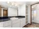 Bathroom featuring a black countertop with a single sink, cabinetry, and adjacent storage shelving at 8752 E Range Rider Trl, Mesa, AZ 85207