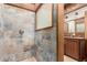 Bathroom featuring shower with stone style walls, wooden vanity, and wood paneling at 8752 E Range Rider Trl, Mesa, AZ 85207