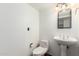 Simple half bathroom with a pedestal sink, toilet, and tiled floors at 8752 E Range Rider Trl, Mesa, AZ 85207