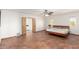Bright bedroom with warm terracotta tile floors, neutral walls, and access to the bathroom at 8752 E Range Rider Trl, Mesa, AZ 85207