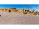 View of tan house with multi-car garage, desert landscaping and gravel drive at 8752 E Range Rider Trl, Mesa, AZ 85207