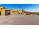 Exterior view of a well-maintained tan home, multiple garages and ample parking on gravel drive at 8752 E Range Rider Trl, Mesa, AZ 85207