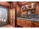 Wood paneled kitchen with carved refrigerator, granite counters, stainless sink, and rustic accents at 8752 E Range Rider Trl, Mesa, AZ 85207