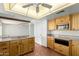 Bright kitchen with wooden cabinets, tile floors, and an island cooktop at 8752 E Range Rider Trl, Mesa, AZ 85207