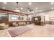Spacious living room with wood paneling, large windows, and a unique desert mural at 8752 E Range Rider Trl, Mesa, AZ 85207