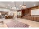Open-concept living room with a bar, wood paneling, and a connecting staircase at 8752 E Range Rider Trl, Mesa, AZ 85207