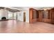 Spacious living room with brick floors, fireplace, built-in shelves, and views of the pool at 8752 E Range Rider Trl, Mesa, AZ 85207