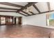 Spacious living room with exposed beams and access to the kitchen and bedrooms at 8752 E Range Rider Trl, Mesa, AZ 85207