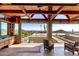 Covered patio showcases wooden beams, wet bar, stone counters, seating, and stunning mountain views at 8752 E Range Rider Trl, Mesa, AZ 85207