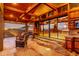 Outdoor patio features wood beams, glass sliders, fireplace, TV, outdoor kitchen, and comfortable seating at 8752 E Range Rider Trl, Mesa, AZ 85207
