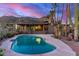 Backyard pool at dusk provides a tranquil setting with desert landscape and scenic mountain views at 8752 E Range Rider Trl, Mesa, AZ 85207