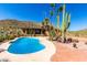 Inviting backyard pool with a desert backdrop, lush greenery, and ample space for relaxation at 8752 E Range Rider Trl, Mesa, AZ 85207