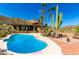 Inviting pool with deck in private backyard with views, mature cacti, and palm trees at 8752 E Range Rider Trl, Mesa, AZ 85207