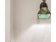 Wall sconce featuring a green patterned glass shade against a white wall at 8752 E Range Rider Trl, Mesa, AZ 85207