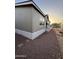 Side view of the light tan home showing gravel landscaping, block pavers, and sunlit setting at 8832 E Pueblo Ave # 20, Mesa, AZ 85208