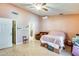 Angle of Primary bedroom featuring a leather couch, fan, walk-in closet, and ensuite bathroom at 8942 W Peck Dr, Glendale, AZ 85305