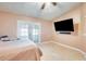 Cozy bedroom with TV, ceiling fan and access to the outdoor patio at 8942 W Peck Dr, Glendale, AZ 85305