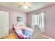 View of the bedroom with a white bed, light purple walls, a window, and a door at 8942 W Peck Dr, Glendale, AZ 85305