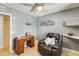 This bedroom features hardwood floors, a ceiling fan, a wood desk, and a comfortable brown leather chair at 8942 W Peck Dr, Glendale, AZ 85305