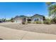 View of the home highlighting the three-car garage, desert landscaping, and a welcoming entryway at 8942 W Peck Dr, Glendale, AZ 85305