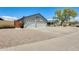 Exterior shot of the home featuring a three-car garage, landscaped yard, and a pergola-covered porch at 8942 W Peck Dr, Glendale, AZ 85305