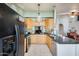 Well-lit kitchen with wooden cabinets, black countertops, and stainless steel appliances at 8942 W Peck Dr, Glendale, AZ 85305