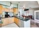 Bright kitchen featuring an island with sink, granite countertops, and open access to the living area at 8942 W Peck Dr, Glendale, AZ 85305