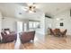 Spacious living room featuring comfortable leather armchairs and wood-look laminate flooring at 8942 W Peck Dr, Glendale, AZ 85305