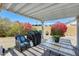 Inviting covered patio with grill, chair, table and colorful bougainvillea bushes in the background at 8942 W Peck Dr, Glendale, AZ 85305