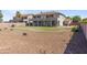 Wide backyard view showcasing desert landscaping, lawn, and a covered patio at 9548 W Keyser Dr, Peoria, AZ 85383