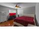 Cozy bedroom with a ceiling fan, plush headboard, hardwood floors and a bright window at 9548 W Keyser Dr, Peoria, AZ 85383