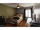 This bedroom features a wrought iron bed frame, ceiling fan, and a bright window view at 9548 W Keyser Dr, Peoria, AZ 85383