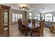 Formal dining room with a large wooden table and a view to the living area at 9548 W Keyser Dr, Peoria, AZ 85383