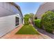 Small backyard featuring green artificial turf and brick patio between homes at 9636 N 53Rd Ave, Glendale, AZ 85302