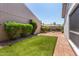 Brick-paved backyard with artificial turf and manicured bushes in a private outdoor area at 9636 N 53Rd Ave, Glendale, AZ 85302