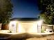 Charming home exterior with brick accents, a two-car garage, and a manicured front yard at night at 9636 N 53Rd Ave, Glendale, AZ 85302