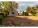 Large backyard space with a stucco wall, patio, green trees, and desert landscaping at 10735 W Bermuda Dr, Avondale, AZ 85392