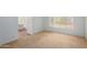 A simple bedroom with carpet, window, and baseboard with white wall and attached bathroom at 10735 W Bermuda Dr, Avondale, AZ 85392