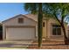 Close up view of a single-story home with a two-car garage and desert landscaping at 10735 W Bermuda Dr, Avondale, AZ 85392