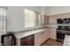 Well-lit kitchen with stainless steel dishwasher, sink, oven, and updated cabinetry at 10735 W Bermuda Dr, Avondale, AZ 85392