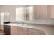 Bright kitchen featuring a stainless steel dishwasher, sink, and neutral-toned cabinetry at 10735 W Bermuda Dr, Avondale, AZ 85392