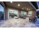 Covered back patio featuring travertine flooring, comfy seating, ceiling fan and backyard views at 13236 W Montansoro Ln, Peoria, AZ 85383