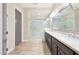 Bathroom featuring a double vanity with granite countertops and a frameless glass shower enclosure at 13236 W Montansoro Ln, Peoria, AZ 85383