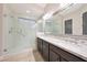 Modern bathroom featuring double sinks with granite countertops and a glass-enclosed walk-in shower at 13236 W Montansoro Ln, Peoria, AZ 85383