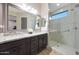 Elegant bathroom with a granite countertop, dual sinks, and a modern glass-enclosed shower at 13236 W Montansoro Ln, Peoria, AZ 85383