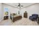 Bedroom featuring light wood floors, traditional furniture, shuttered windows, and a ceiling fan at 13236 W Montansoro Ln, Peoria, AZ 85383