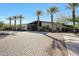 Attractive community entrance with palm trees, lush landscaping, and a well-paved driveway at 13236 W Montansoro Ln, Peoria, AZ 85383