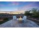 Inviting outdoor fire pit area with seating and desert views beyond the backyard fence at 13236 W Montansoro Ln, Peoria, AZ 85383