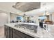 Modern kitchen island cooktop with hood, overlooking the living and dining areas at 13236 W Montansoro Ln, Peoria, AZ 85383